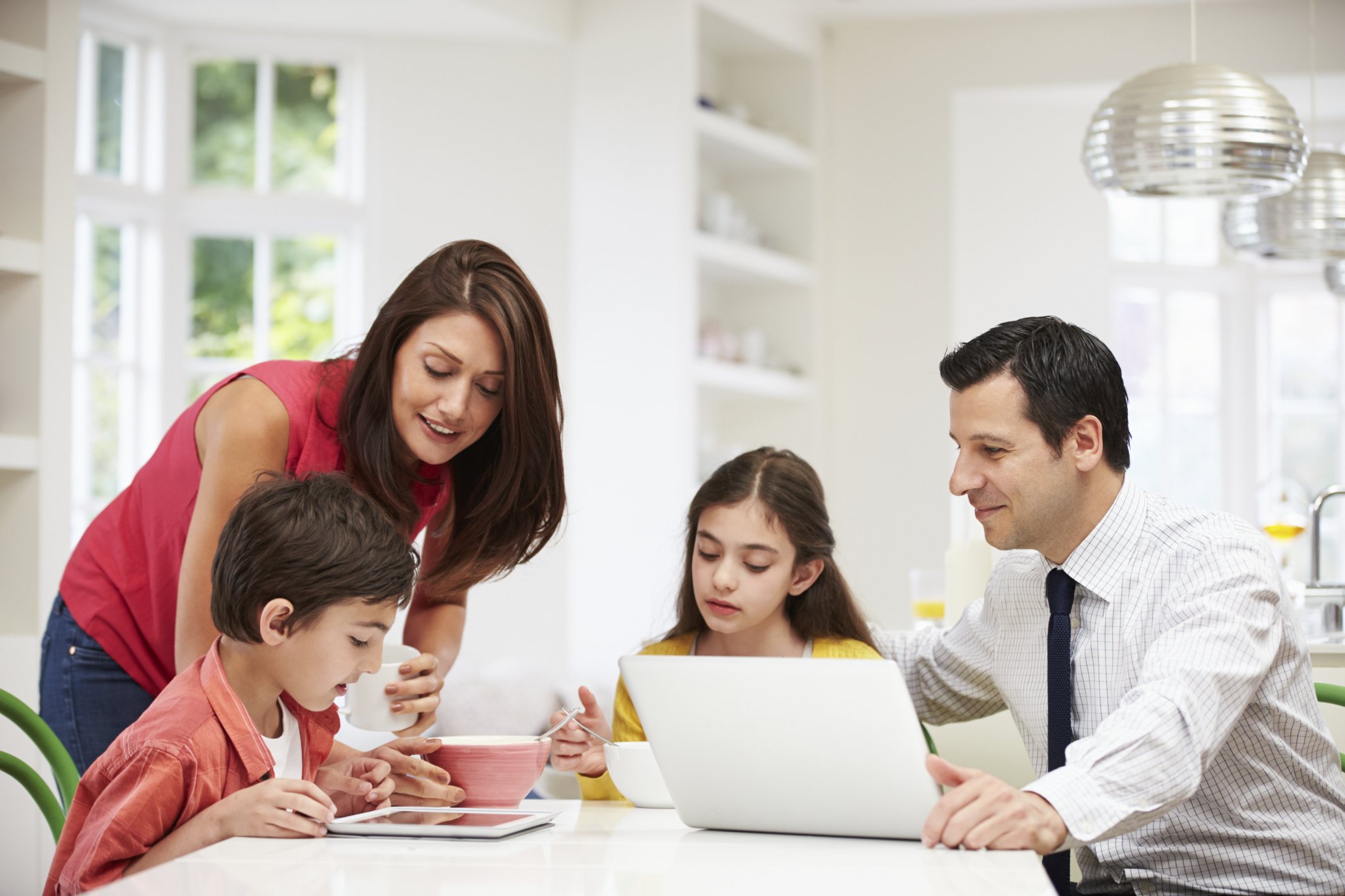 Family using digital devices at breakfast table