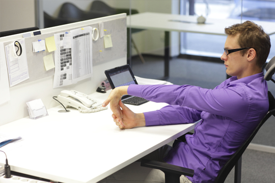 Man exercising at his desk