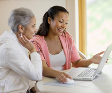 woman showing her mother how to use a laptop