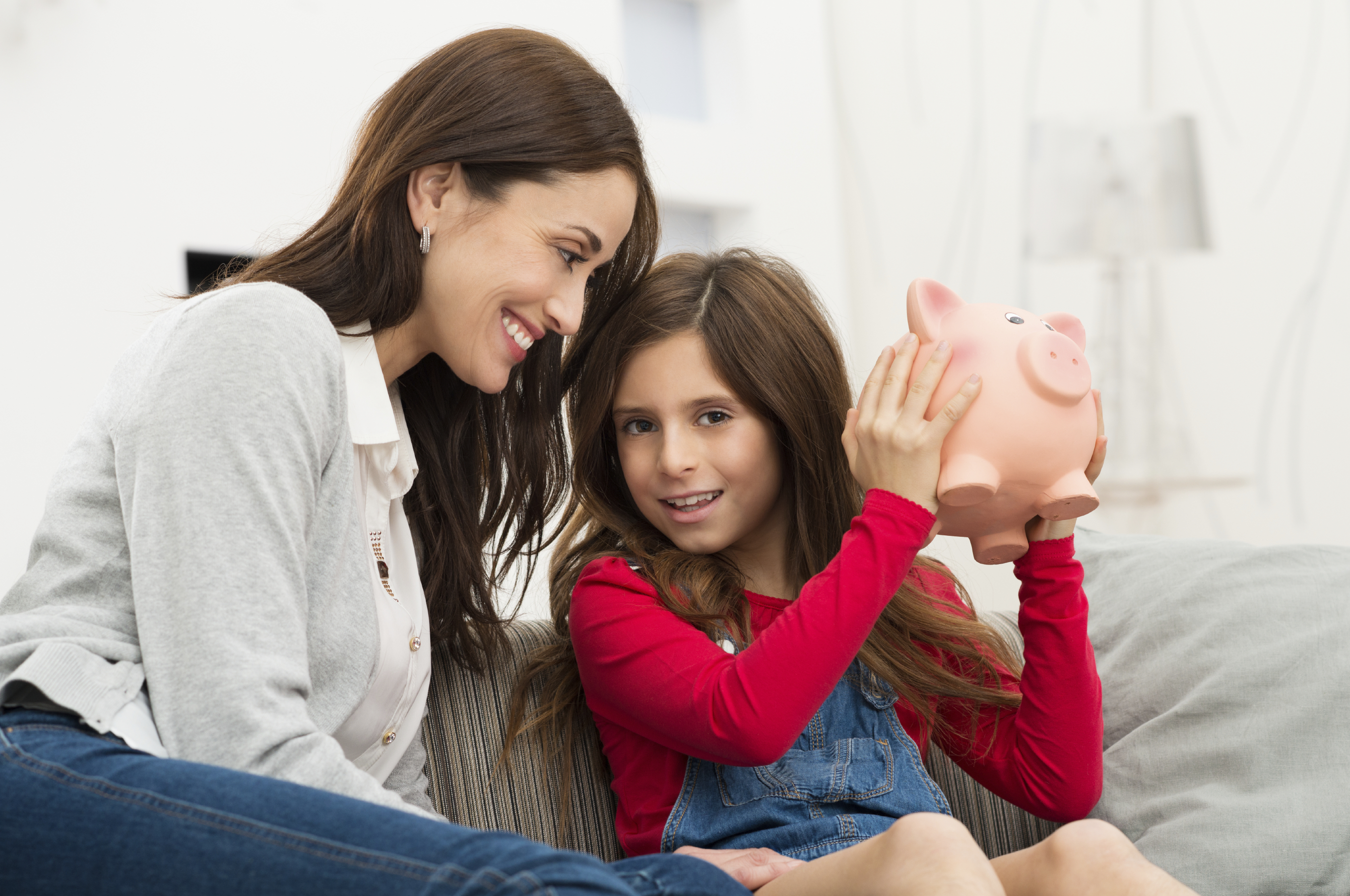 Child putting part of her allowance in her piggy bank
