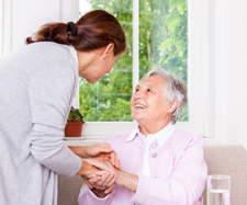 old woman is shaking hands with another woman