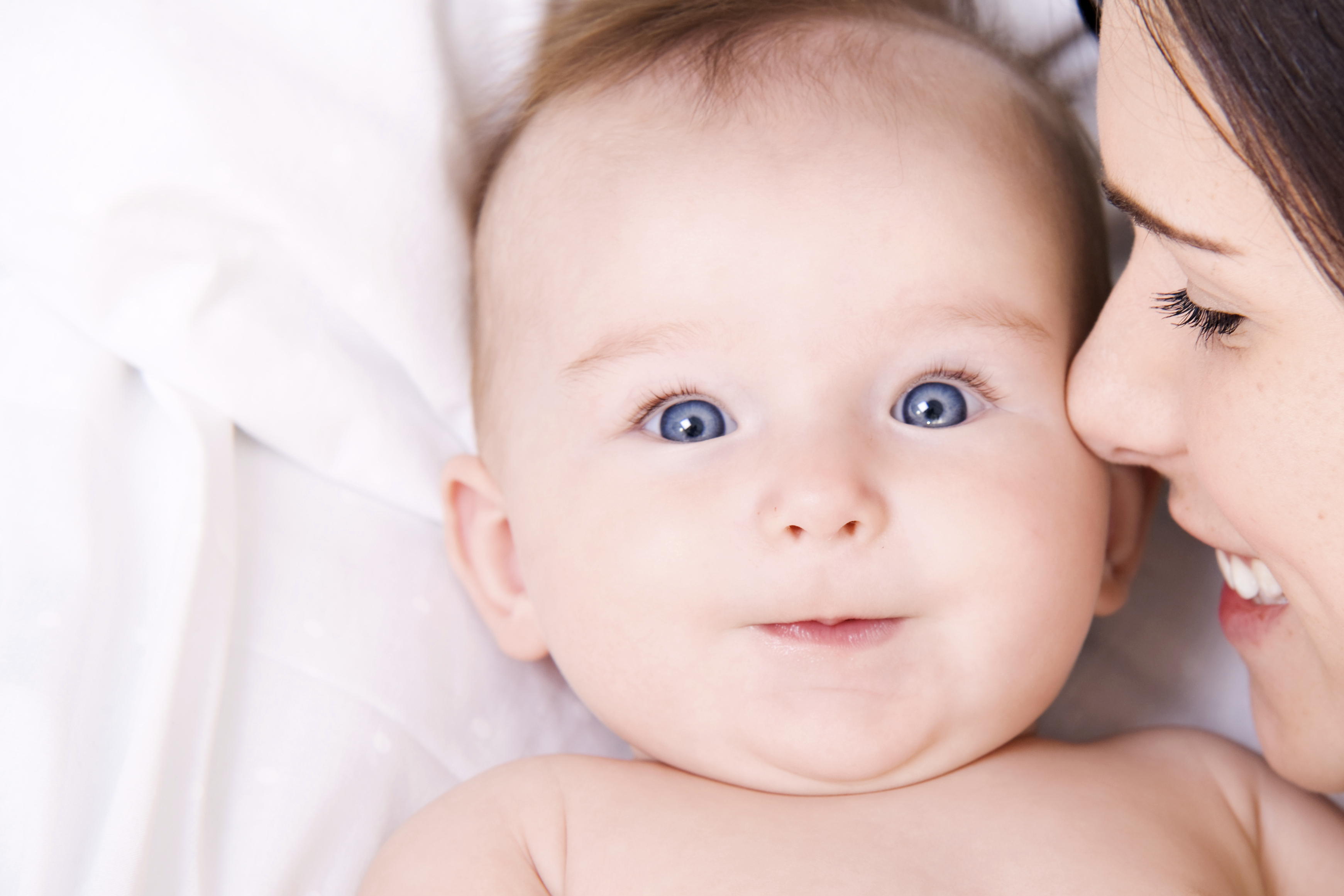close up of mom smiling and holding her newborn baby