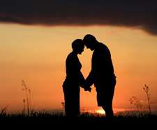 old couple is holding hands at sunset