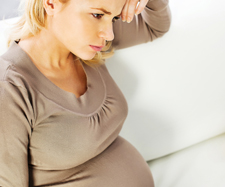 concerned woman holding pregnant belly